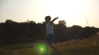 Genç çocukla güneşli günde yeşil çim alan, çalışan uçak eller olarak ortaya çıkar. Çim açık koşu çocuk. Mutlu erkek çocuk yaz çayır üzerinde doğada eğleniyor. Ağır çekim yakın çekim.