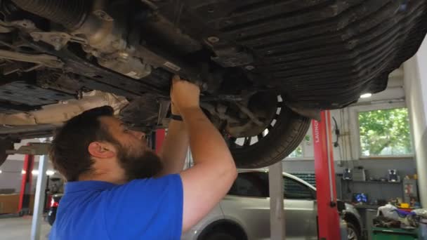 Jonge Automonteur Inspecteert Schorsing Van Een Auto Garage Professionele Bebaarde — Stockvideo