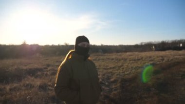 Female ukrainian army soldier standing at field and looking at camera. Serious sight of woman in military camouflage uniform during war. Victory against russian aggression. Invasion resistance concept