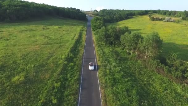 Letecký Záběr Bílého Kabrioletu Projíždějícího Prázdnou Venkovskou Cestou Čtyři Mladé — Stock video