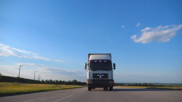 高速走行のトラックのフロント ビュー トラックのバック グラウンドで美しい風景と田園地帯を通って乗り物 スローモーションをクローズ アップ — ストック動画
