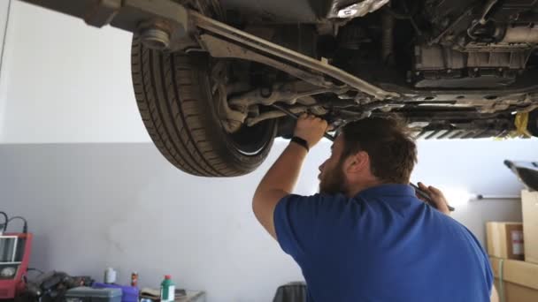 Mécanicien Automobile Barbu Professionnel Travaillant Sous Véhicule Levage Garage Jeune — Video