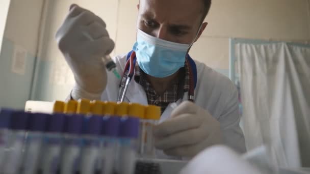 科学家正在研发Covid 19的治疗方法 在实验室工作的医生 医生戴着医疗面罩 用注射器用液体填充试管 保健和验尸报告流行病的概念 — 图库视频影像