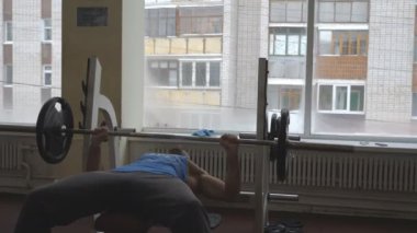 Spor salonunda halterle ağırlık çalışması yapan güçlü bir sporcu. Spor giyimli kaslı sporcu içeride halter egzersizi yapıyor. Sağlıklı ve aktif yaşam tarzı kavramı. Yavaşça kapat..