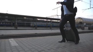 Tanınmayan bir işadamı tren istasyonunda koşuyor ve saatine bakıyor. Genç adam trene geç kaldı. İş adamı, bavuluyla demiryolu yakınlarında koşuyor. İş gezisi kavramı. Yavaş