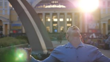 Genç işadamı şehir ortamında başarıyı kutluyor. Başarılı bir adam akıllı telefondan iyi haberler alıyor ve olumlu duygular besliyor. Adam başarıya seviniyor. Yavaş çekim. Yakın çekim..
