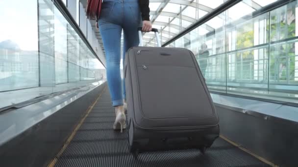 ビジネスの女性の足彼女の荷物とターミナルのホールを通過する かかとの高いステップで認識できない女の子と車輪の上にスーツケースをロール 女性は旅行に行く 出張のコンセプト — ストック動画
