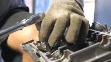 Otomobilden sökülmüş motora bakın. Tanımlanamayan tamirci araba motorunu tamir ediyor. Adam işi için alet kullanıyor. Tamirci garajda ya da atölyede çalışıyor. Yavaş çekim. Yakın çekim..