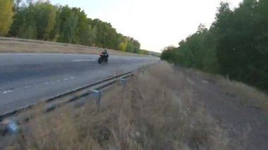 Autumn Highway 'de modern spor motosiklet kullanan motosikletlinin havadan çekilmiş fotoğrafı. Motosikletli, kır yolunda motosikletiyle yarışıyor. Yolculuk sırasında bisiklet süren adam. Yolculuktaki özgürlük ve macera kavramı.