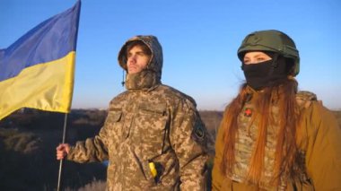 Ukrayna bayrağı sallayan Ukrayna ordusunun askerleri. Askerler, Rus saldırısına karşı zafer kazanmak için bayrağı kaldırdı. İstila direnişi ve savaşın sonu kavramı. Yavaş çekim.