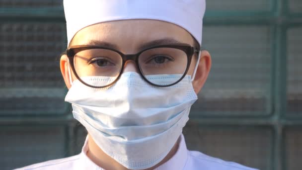 Retrato Jovem Médica Com Máscara Facial Médica Olha Para Câmera — Vídeo de Stock
