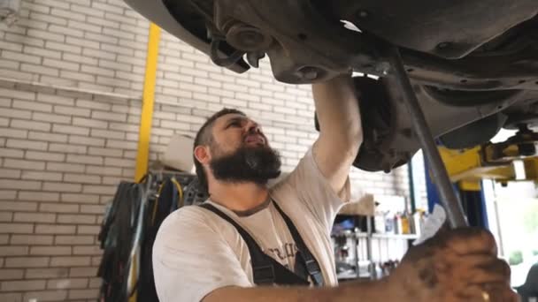 Repairman Dalam Seragam Memeriksa Suspensi Mobil Bengkel Mekanik Mobil Berjenggot — Stok Video