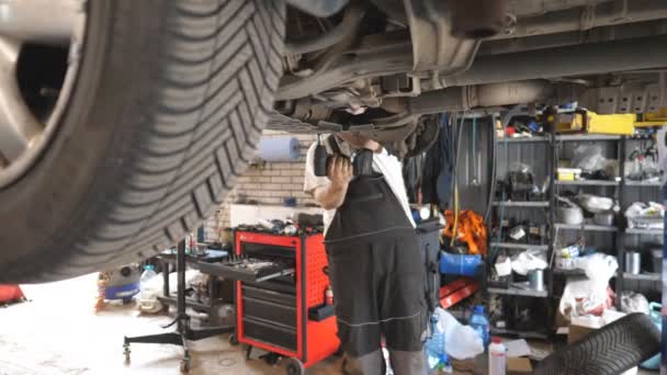 Professionele Automonteur Die Onder Een Hefvoertuig Garage Werkt Onherkenbare Reparateur — Stockvideo