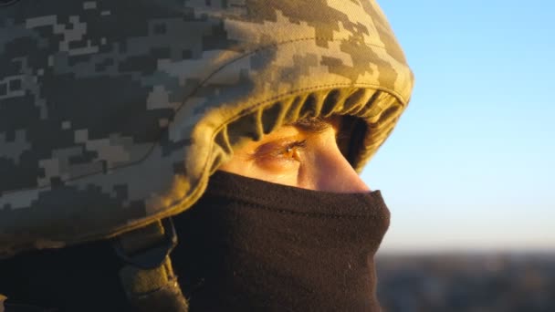 穿着头盔和巴拉克拉瓦的男性乌克兰士兵的凝视 年轻军人在日落时满怀希望的形象 抵抗入侵 俄罗斯和乌克兰之间的战争 靠近点 — 图库视频影像