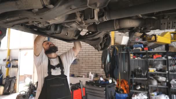 Professionele Bebaarde Auto Monteur Werken Onder Een Hefvoertuig Dienst Garage — Stockvideo