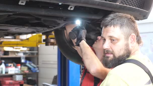 Två Mekaniker Inspekterar Upphängningen Bilen Vid Automatisk Service Professionella Reparatörer — Stockvideo