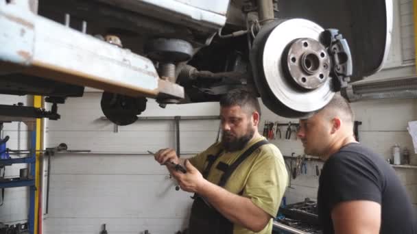 Deux Mécaniciens Automobiles Discutent Entretien Voiture Atelier Garage Réparateurs Debout — Video