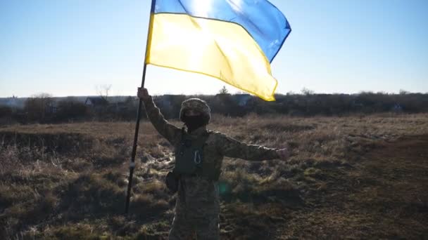 Ουκρανός Στρατιώτης Σηκώνει Μπλε Κίτρινη Σημαία Στέκεται Στο Γήπεδο Νεαρός — Αρχείο Βίντεο