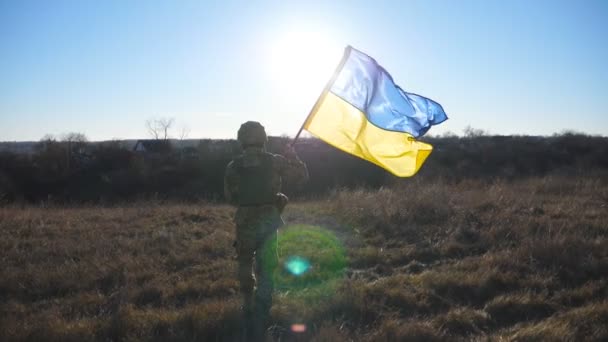 Άντρας Στρατιώτης Του Ουκρανικού Στρατού Τρέχει Υψωμένη Εθνική Σημαία Στο — Αρχείο Βίντεο