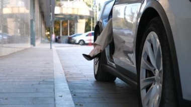 Zarif iş kadını ofis binasının yakınındaki modern arabadan indi. Genç iş kadını arabadan çıkıp işe ya da iş toplantısına gider. Takım elbiseli ve topuklu ayakkabılı bayanın işe gidişi. Yavaş çekim