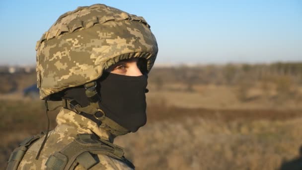 穿着头盔和巴拉克拉瓦的男性乌克兰士兵的凝视 年轻军人带着胜利的希望看简况 抵抗入侵 俄罗斯和乌克兰之间的战争 靠近点 — 图库视频影像
