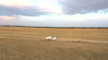 Kalkıştan önce kırsal alan boyunca küçük bir uçak sürüyordu. Hafif uçak havaalanından önceki uçuş için piste doğru gidiyor. Hafif uçak uçmaya hazırlanıyor. Havacılık kavramı