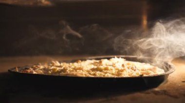 Lezzetli dört peynirli pizza mutfak restoranında elektrikli fırında pişiyor. Mozzarella, çedar, parmesan peyniri ve fırında eriyen feta. Yemek hazırlama süreci. Kapat.