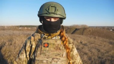 Kasklı ve kar maskeli Ukraynalı asker kadın portresi. Askeri doktor olay yerinde kameraya doğru bakıyor. Rus saldırısına karşı barış ve destek kavramı. Savaşın sonu.