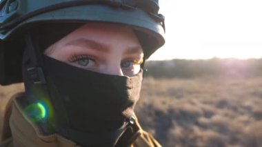 Kasklı Ukraynalı kadın asker görülmüş. Kamuflaj üniformalı genç kadın portresi kameraya özgüvenle bakıyor. Savaş sırasında askeri güçler. Rus işgali Ukrayna 'da. Kapat..