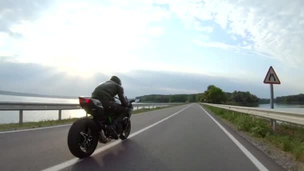 Motociclista Montar Moto Deportiva Moderna Través Carretera Cerca Del Lago — Vídeos de Stock