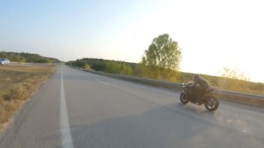 Güneşli bir sonbahar gününde otoyolda motosiklet süren bir bisikletçi. Motosikletli, kır yolunda motosikletiyle yarışıyor. Yolculuk sırasında bisiklet süren bir adam. Özgürlük ve macera kavramı. Hava görüntüsü