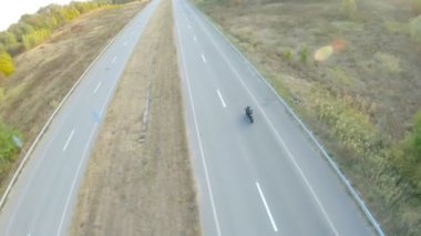 Otobanda motosiklet süren motosikletli bir motorcunun kamera görüntüsü. Motosikletli gün batımında kır yolunda motosikletiyle yarışıyor. Yolculuk sırasında bisiklete binen adam. Özgürlük ve macera kavramı.