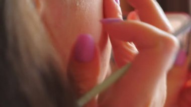 Genç tanınmayan bir kız aynaya bakıyor ve cilt kremi sürüyor. Makyaj yaparken kendine dikkat eden çekici bir kadın. Güzellik ve tarz kavramı. Yavaş çekim Ayrıntılı görünüm.