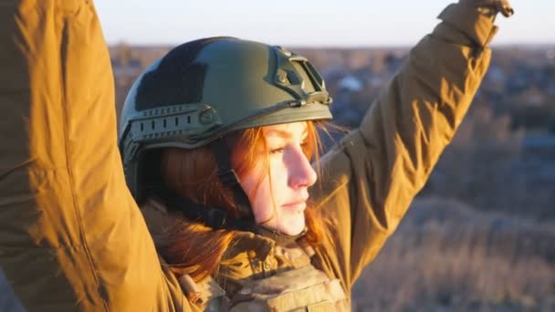 乌克兰女兵站在乌克兰国旗下 遥望远方 身穿军服 头戴安全帽的女人满怀希望地看着地平线 战胜俄罗斯的侵略 — 图库视频影像