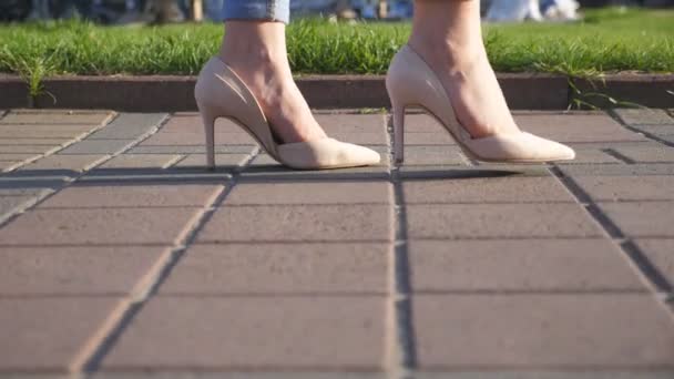 都会の通りを歩くハイヒールの靴の女性の足 街に行くハイヒールの履物で若い女性の足 歩道を歩いている女の子 ローエンジェルビュースローモーション閉じる — ストック動画