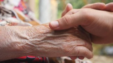 Genç erkek ve kırışmış eller açık birbirlerine okşayarak kapatın. Aile dışında birlikte vakit. Bakım ve sevgi kavramı. Yan görünümü ağır çekim.