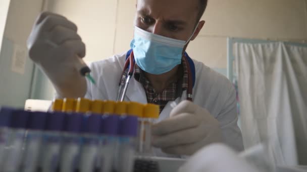 Covid 19の治療法を開発する科学者 研究室で働いている医師 医師は医療用マスクを着用し 手袋は注射器を使用して液体で試験管を充填 医療とコロナウイルスのパンデミックの概念 — ストック動画