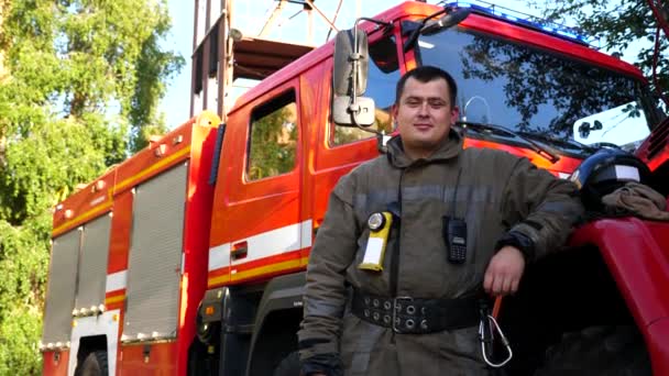 Portret Szczęśliwego Młodego Fireguarda Mundurze Tle Wozu Strażackiego Mężczyzna Strażak — Wideo stockowe