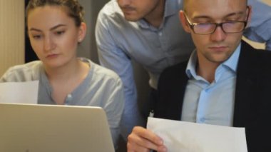 Ofisteki bilgisayardaki istatistiksel verileri inceleyen genç iş arkadaşları. Profesyonel yöneticiler masada oturan iş geliştirme üzerinde çalışırlar. Şirket projesi için iş arkadaşları planlama stratejisi.