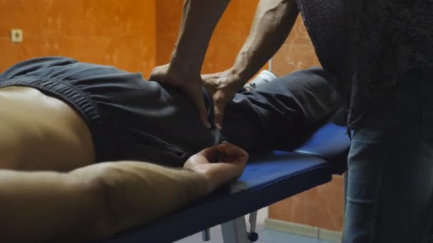 Arme Des Massagetechnikers Der Dem Jungen Athleten Der Auf Dem — Stockvideo