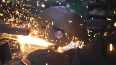 Metal öğüten profesyonel işçilerin elleri. Endüstriyel imalatta çelik testeresi. Birçok parlak kıvılcım sıcak metalden uçar. Garajdaki kesim makinesini gördüm. Yavaş çekim. Yakın çekim..