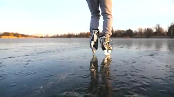 凍った川で若い男のスケートに従ってください フィギュアスケートの男の靴氷の上にスライドします 冬のアクティブなレジャー ホッケー選手は屋外でトレーニングし 寒い気候でスポーツを楽しんでいます スローモーションリアビュー — ストック動画
