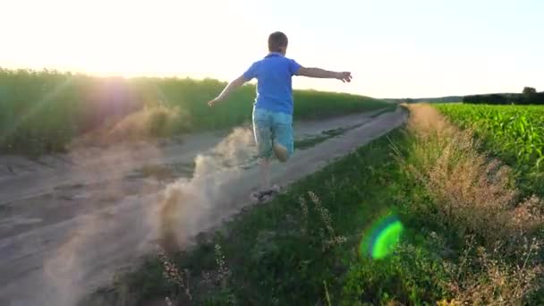 Back View Small Boy Running Dry Ground Road Leaving Dust — Stock Video