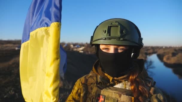 Kobieta Medyk Wojskowy Ukraińskiej Armii Machającą Flagą Ukrainy Patrzy Kamerę — Wideo stockowe