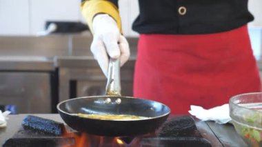 Tanınmayan şef modern otel mutfağında lezzetli vejetaryen yemekleri hazırlıyor. Restoran ziyaretçileri için yemek pişiren profesyonel bir aşçı. Yemek hazırlama konsepti. Yavaş çekim Ön görünümü kapat.