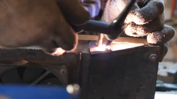 车库或车间焊接工作的详细视图 机修工用专业设备焊接一些金属零件 关闭焊机上的闪光 慢动作 — 图库视频影像