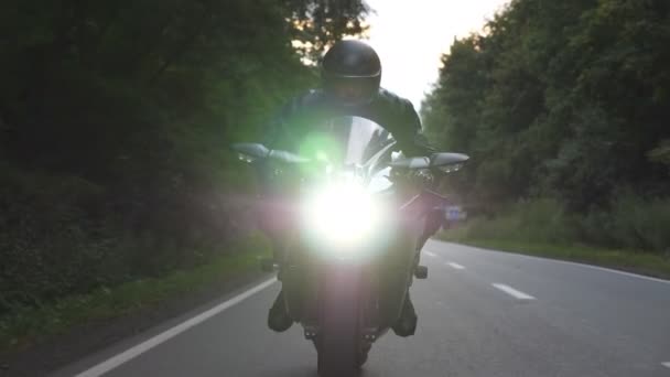 ウッドランドの田舎道で現代的なバイクに乗っています 森林国の道路上のオートバイでオートバイ旅行 旅行中にバイクを運転する男 自由のライフスタイルと冒険の概念 閉じろ — ストック動画