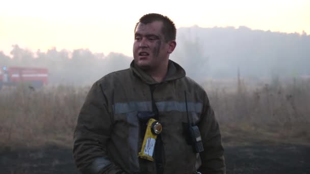 Yangından Sonra Dumanlı Çimlerde Üniformalı Erkek Itfaiyecinin Portresi Genç Itfaiyeci — Stok video
