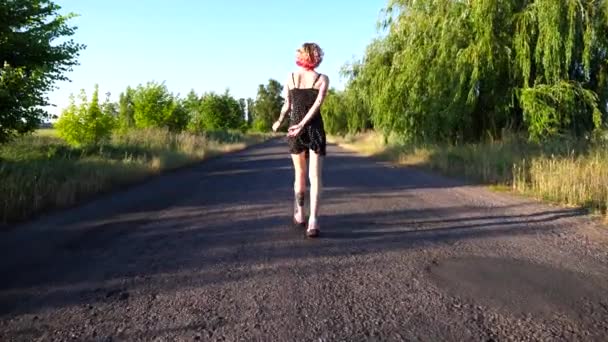Siyah Elbiseli Genç Hippi Kadın Kırsalda Boş Bir Yolda Yürüyor — Stok video