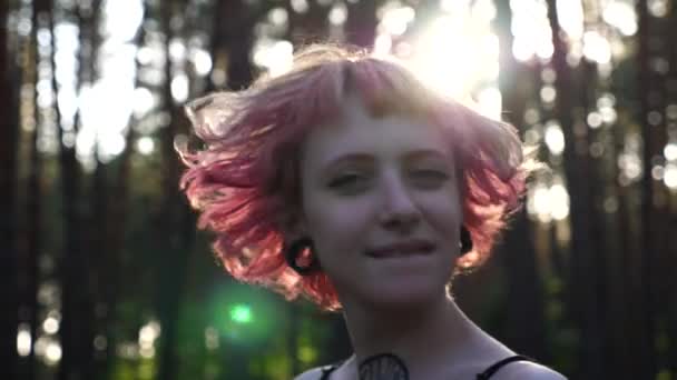 ウッドランドの耳トンネルで笑顔の女性ヒップスターの肖像画 ハッピーパンクの少女が森でカメラを眺めている 夏の自然の中で休むことを楽しんでいるケアフリーのヒッピー女性 自由という概念 クローズアップ — ストック動画